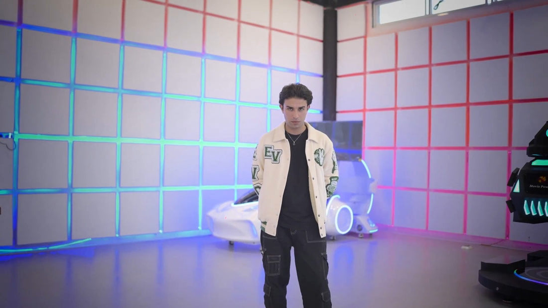 Model wearing an Emporio Vogue cream varsity jacket in a neon-lit studio